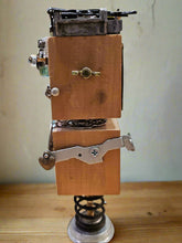 The Handmade Wood Block Steampunk Robot is a unique, decorative figurine crafted from wood with an aged, rustic look. Each robot is one-of-a-kind for display only. Includes a heart-shaped balloon. Available in various sizes, it&