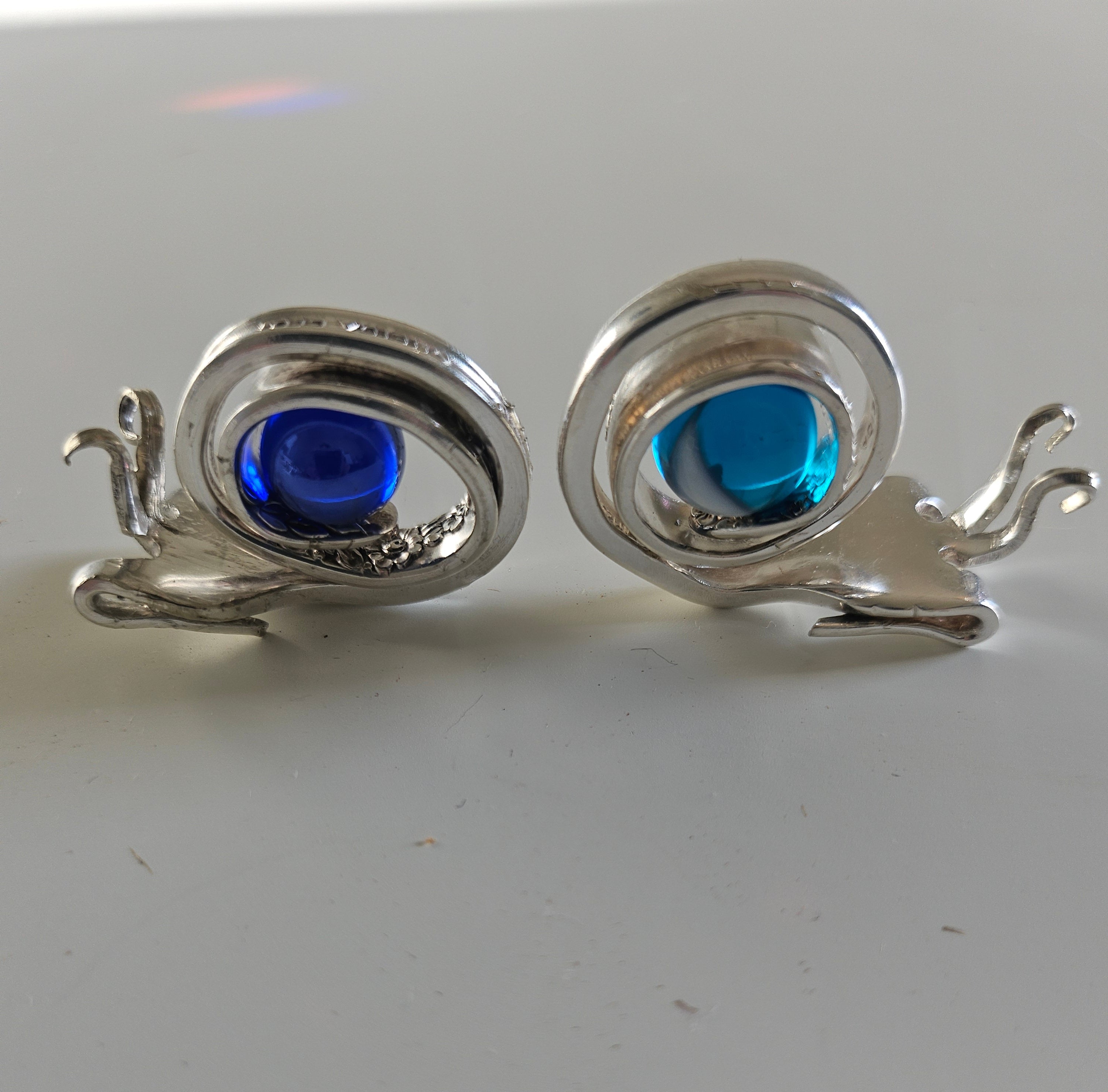 Handcrafted from vintage silverware, these whimsical snails feature shimmering glass orb shells—each a one-of-a-kind symbol of patience and charm.