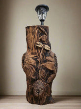 The Hand-Carved Dragonfly Outdoor Planter and Solar Light Wood Spirit in Solid Walnut (30" x 10"). 100% handmade, each piece is unique and perfect for home decor. The natural walnut grain and artisanal craftsmanship add rustic charm, making it a standout decorative piece for any space.