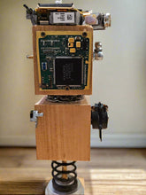 The Handmade Wood Block Steampunk Robot is a unique, decorative figurine crafted from wood with an aged, rustic look. Each robot is one-of-a-kind for display only. Includes a heart-shaped balloon. Available in various sizes, it&