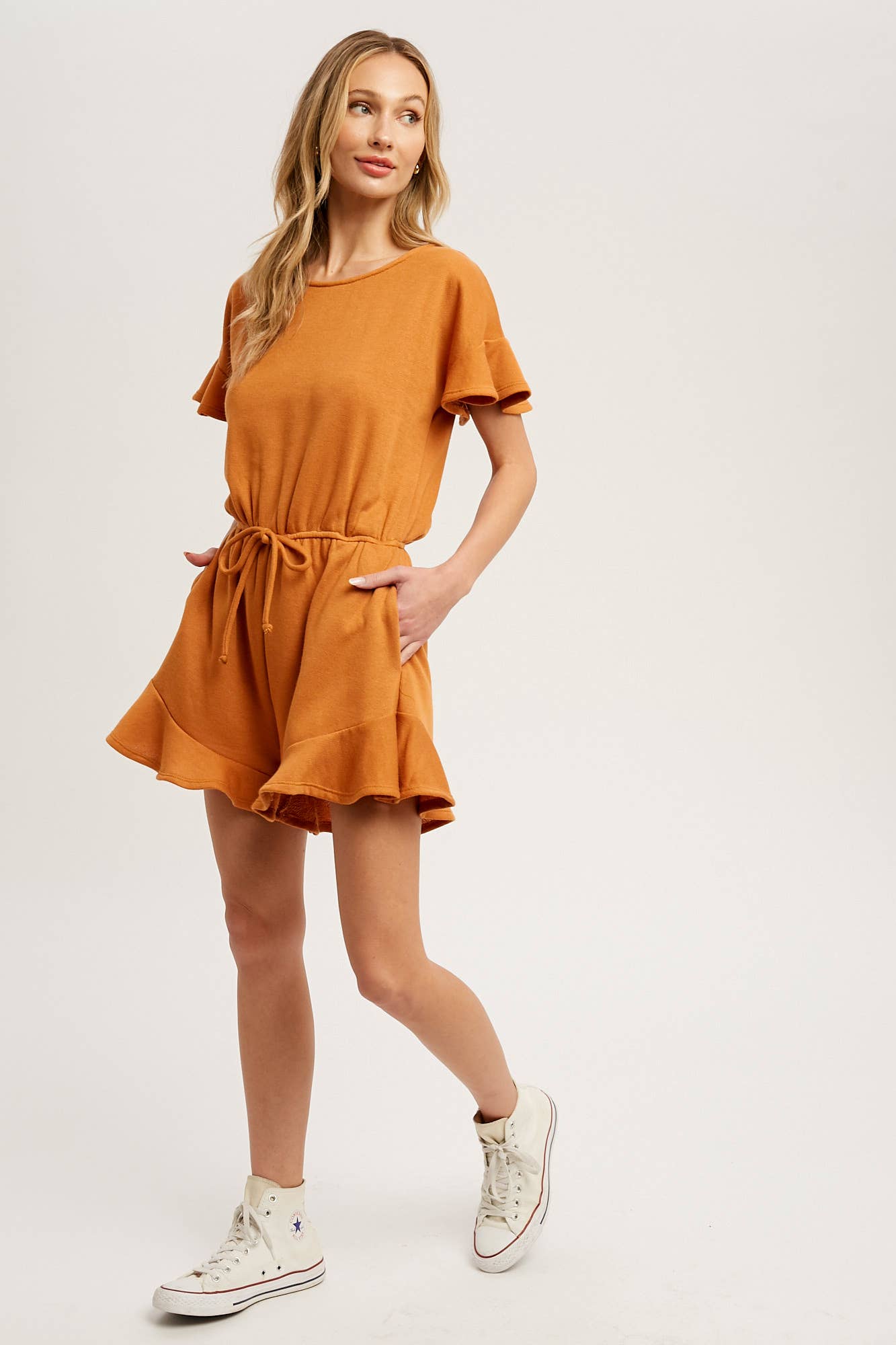 Soft French terry romper with ruffled sleeves, elastic waist, pockets & back button closure. Comfy, cute, and perfect for sunny days or casual outings.