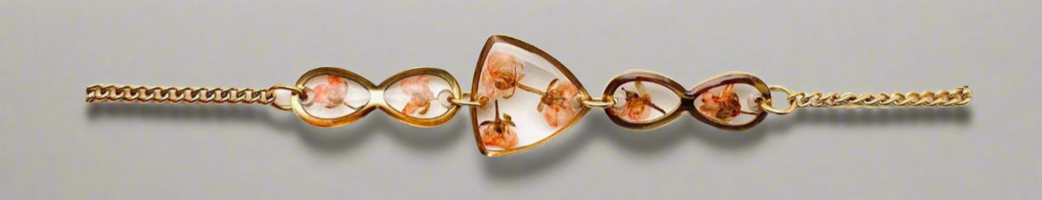 Gold-plated bracelet with real dried flowers in a geometric resin charm. Lightweight, adjustable, and perfect for nature-inspired, elegant everyday wear.