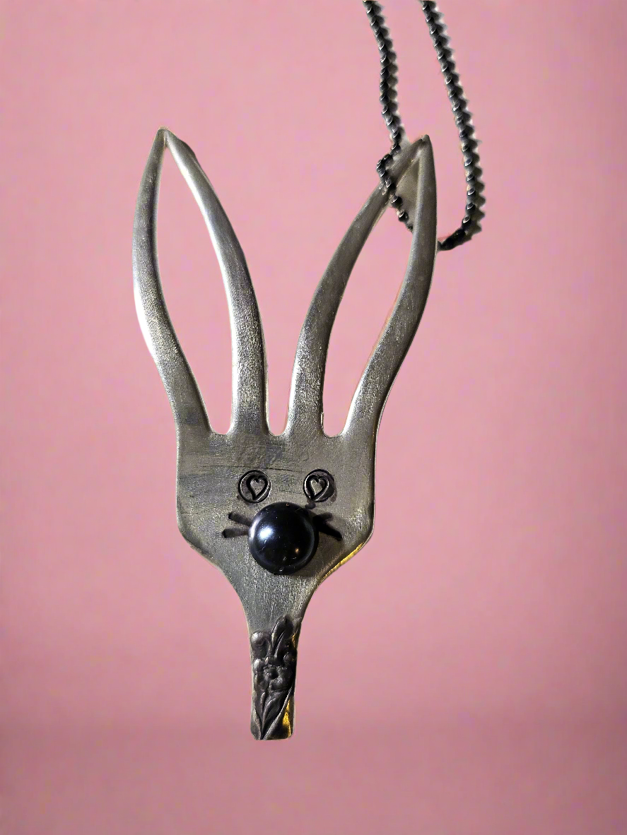 The Salvaged Silver Bunny Pendant is a handcrafted, one-of-a-kind piece made from recycled vintage silverware. Designed by artisan KStonely, it blends whimsical Easter charm with sustainable craftsmanship. Lightweight and unique, it’s perfect for everyday wear or special occasions. A timeless, upcycled treasure that celebrates history and artistry.