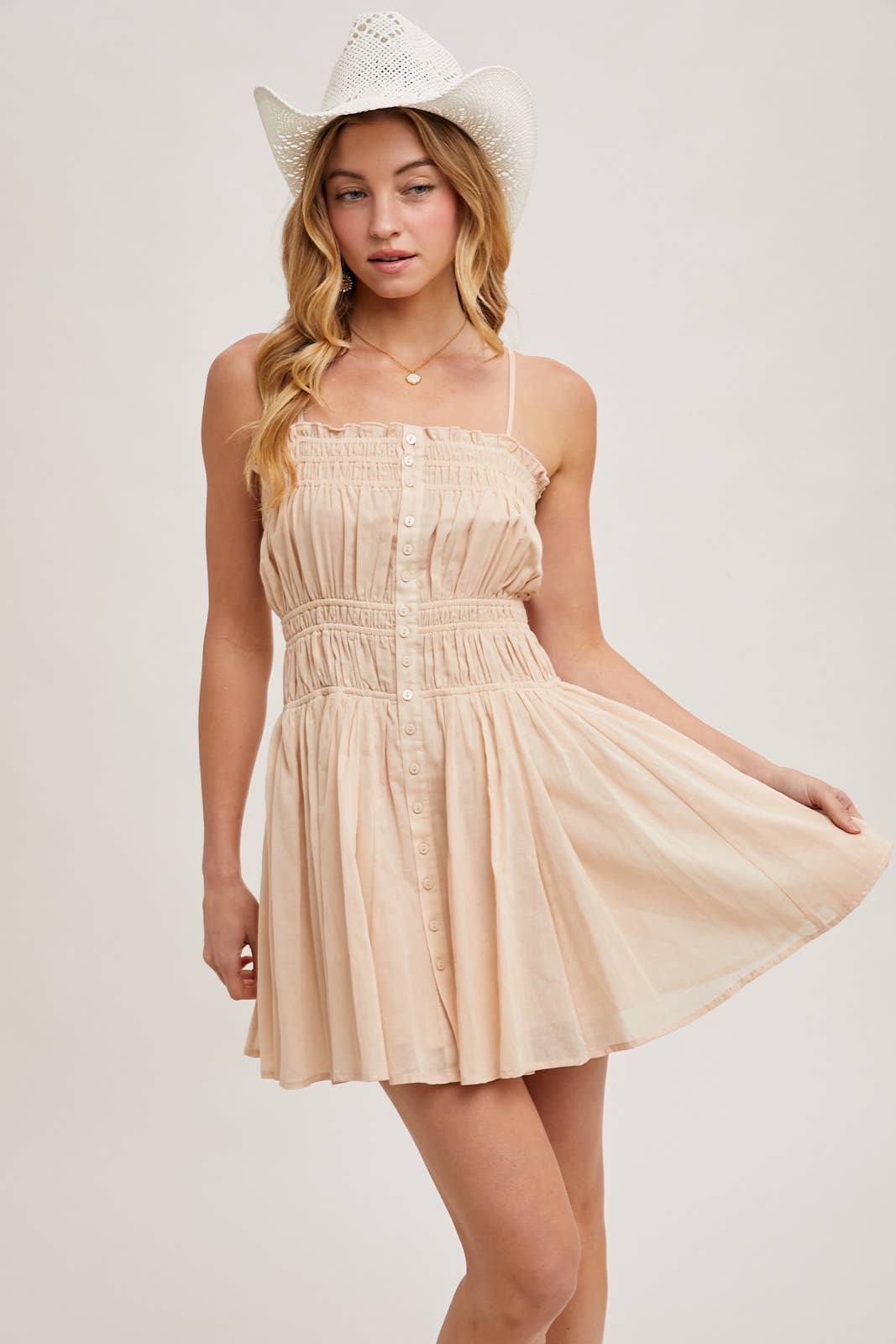 Smocked mini dress with button-down front, adjustable straps & breezy skirt. A flattering, lightweight style perfect for summer days & casual outings.