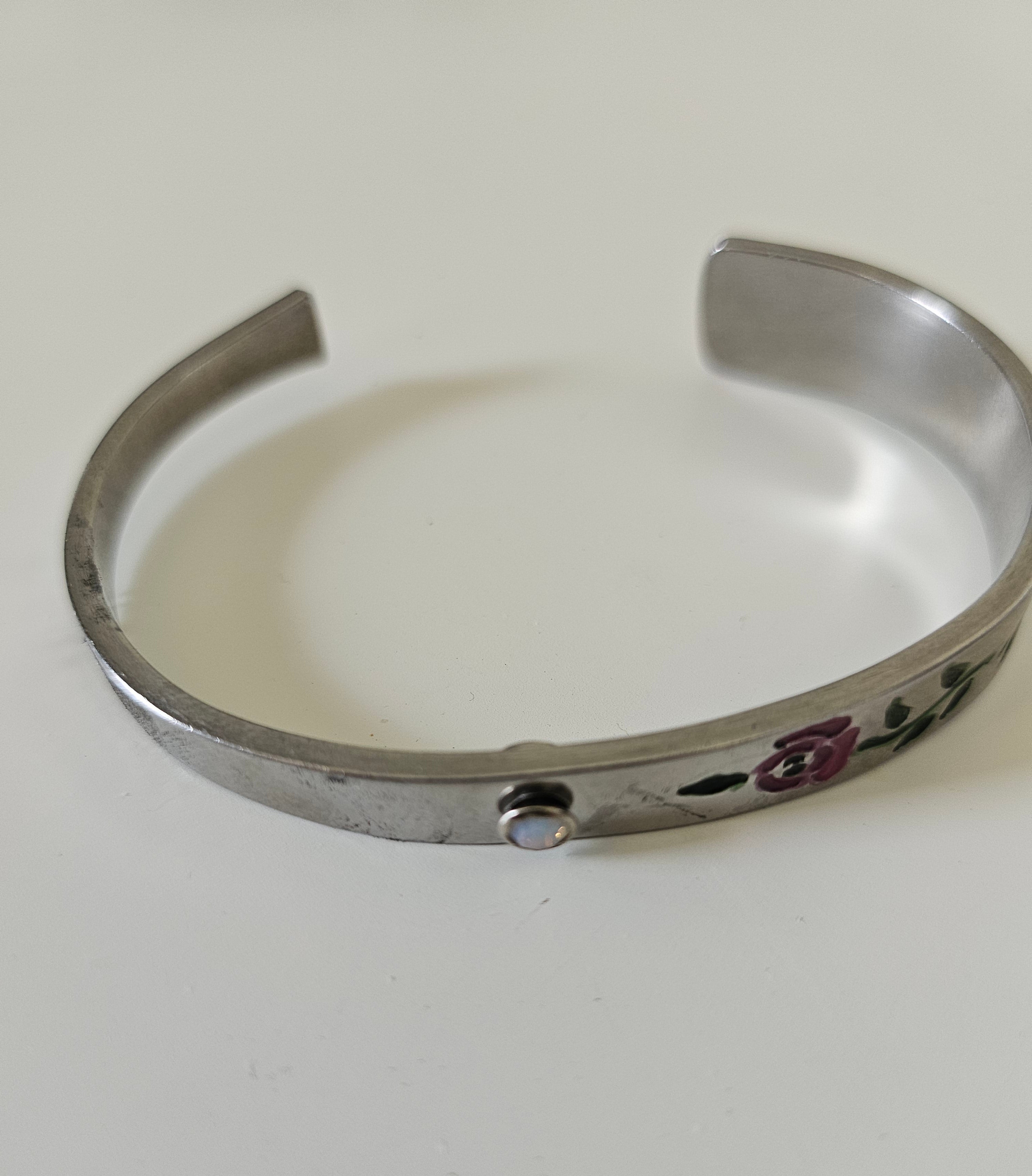 Handcrafted 6" floral cuff bracelet made from vintage silverware with a jewel accent. A one-of-a-kind piece blending antique charm and timeless elegance.