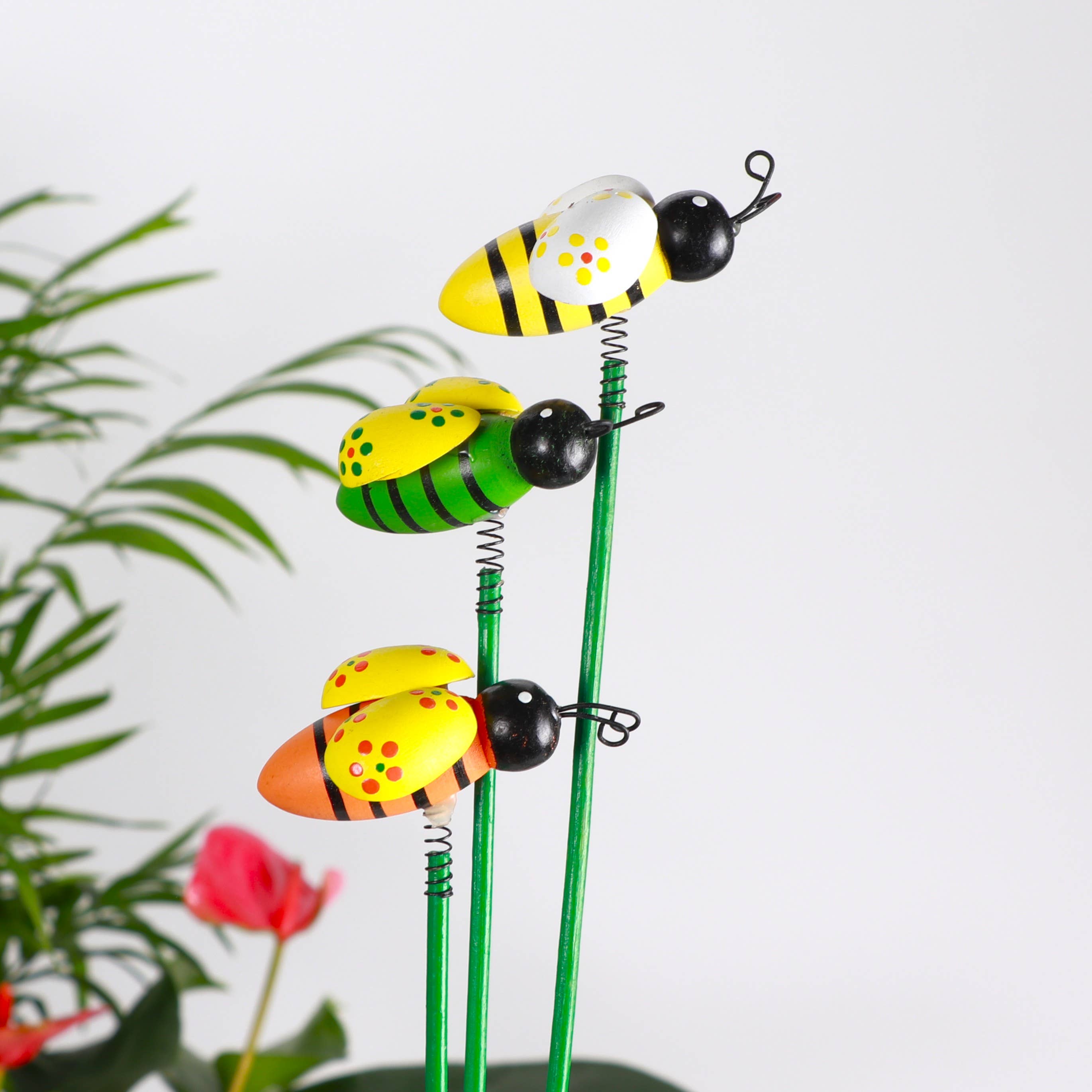 Whimsical bee plant picks with wooden bees on springs. Adds playful movement to houseplants and gardens. Adjustable 19" stake. No plants included.