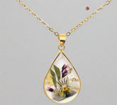 Teardrop necklace with real pressed dried flowers in resin. Unique floral charm with stainless steel chain and copper frame. Nature-inspired and handcrafted.