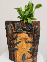 This Hand-Carved & Painted Wood Spirit Planter in solid walnut features intricate details and black-painted accents. 100% handmade, each piece is unique and perfect for home decor or garden. The natural walnut grain and artisanal craftsmanship add rustic charm, making it a standout decorative piece for any space.