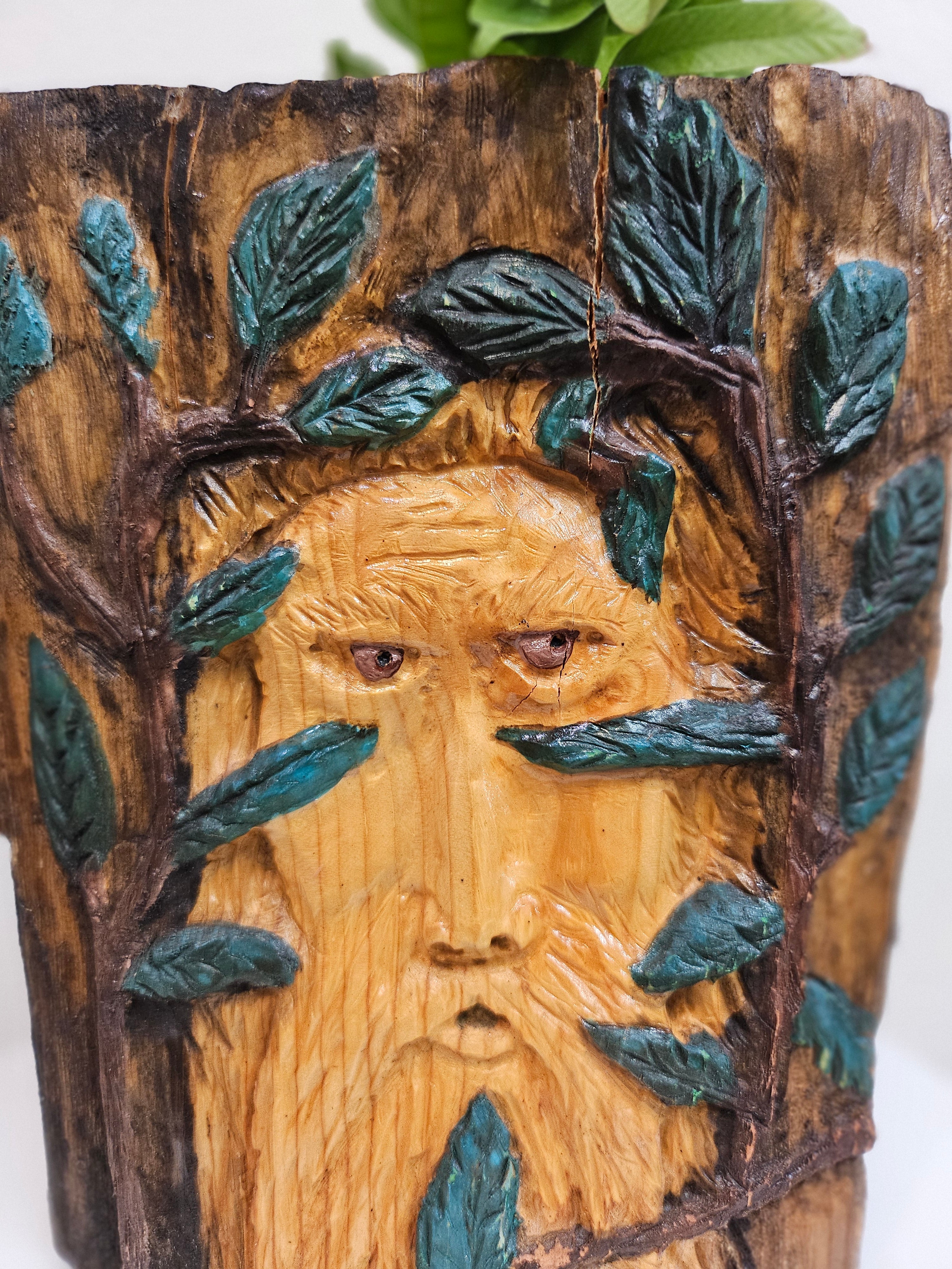 This Hand-Carved & Painted Wood Spirit Planter in solid walnut features intricate details and black-painted accents. 100% handmade, each piece is unique and perfect for home decor or garden. The natural walnut grain and artisanal craftsmanship add rustic charm, making it a standout decorative piece for any space.