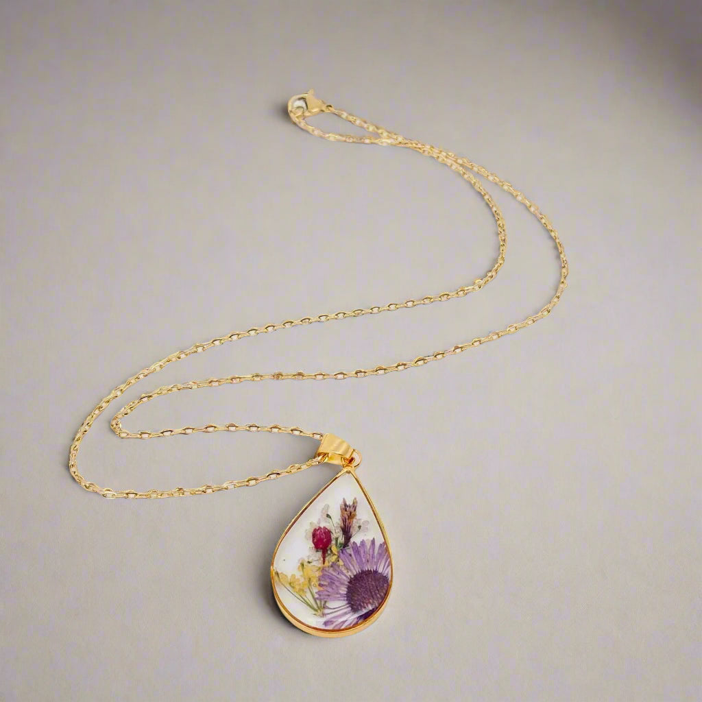 Teardrop necklace with real pressed dried flowers in resin. Unique floral charm with stainless steel chain and copper frame. Nature-inspired and handcrafted.