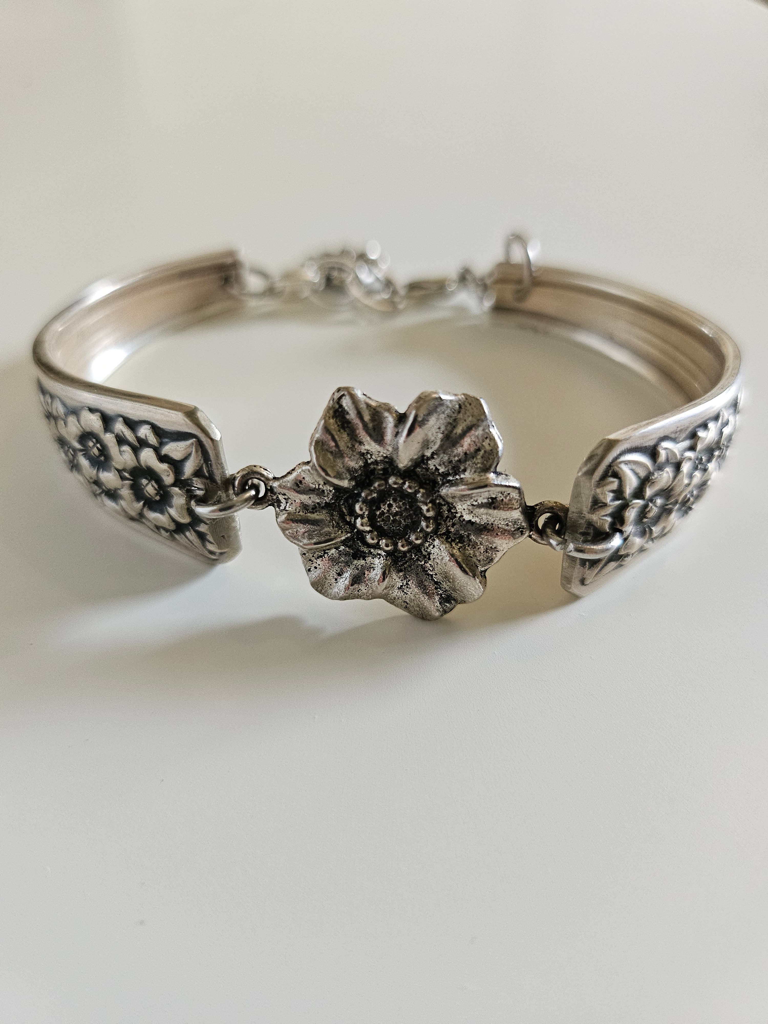 Handcrafted bracelet made from 1953 Jubilee silverware with vintage floral beads. A unique, repurposed piece blending antique charm and modern elegance.