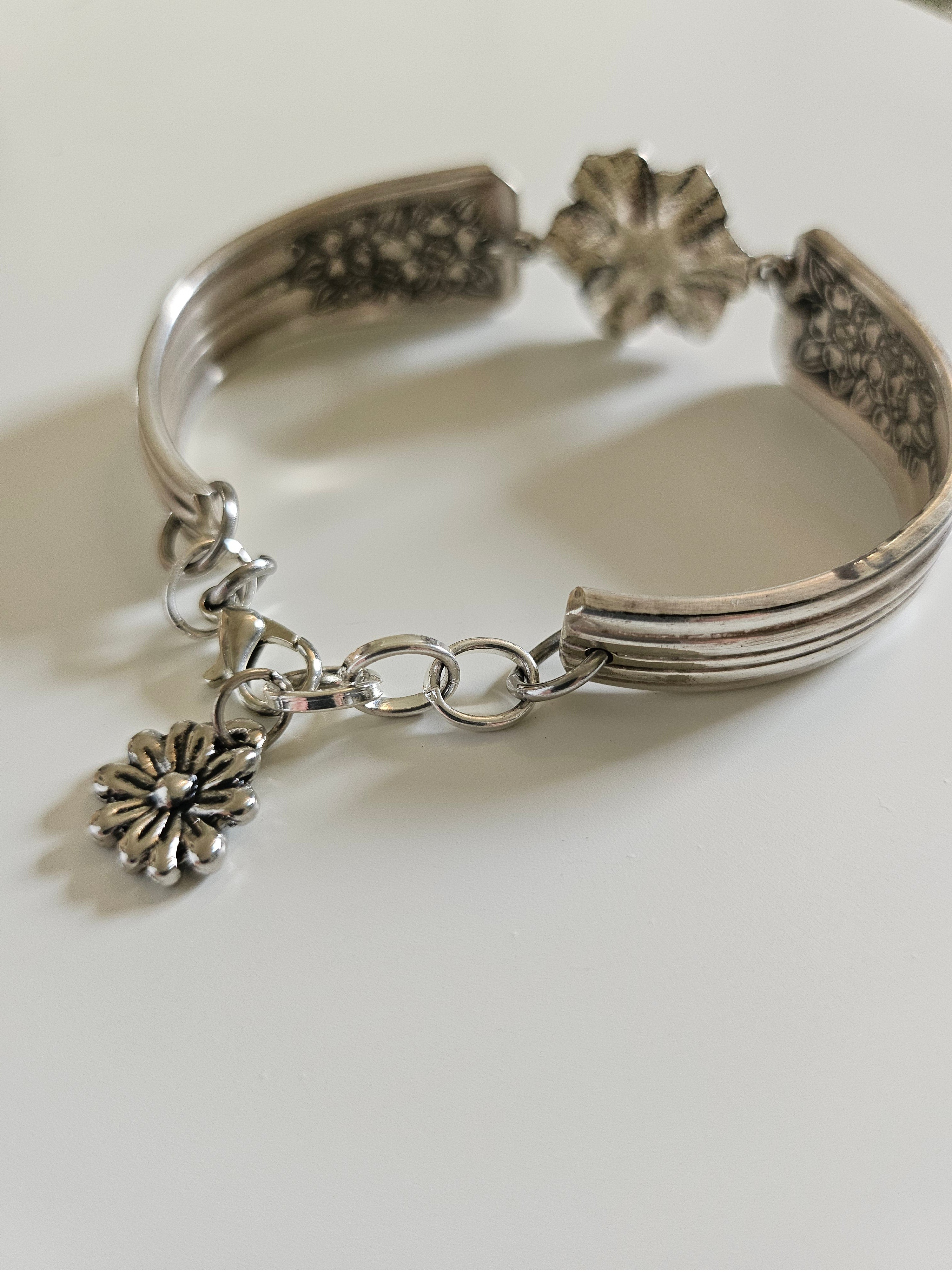 Handcrafted bracelet made from 1953 Jubilee silverware with vintage floral beads. A unique, repurposed piece blending antique charm and modern elegance.