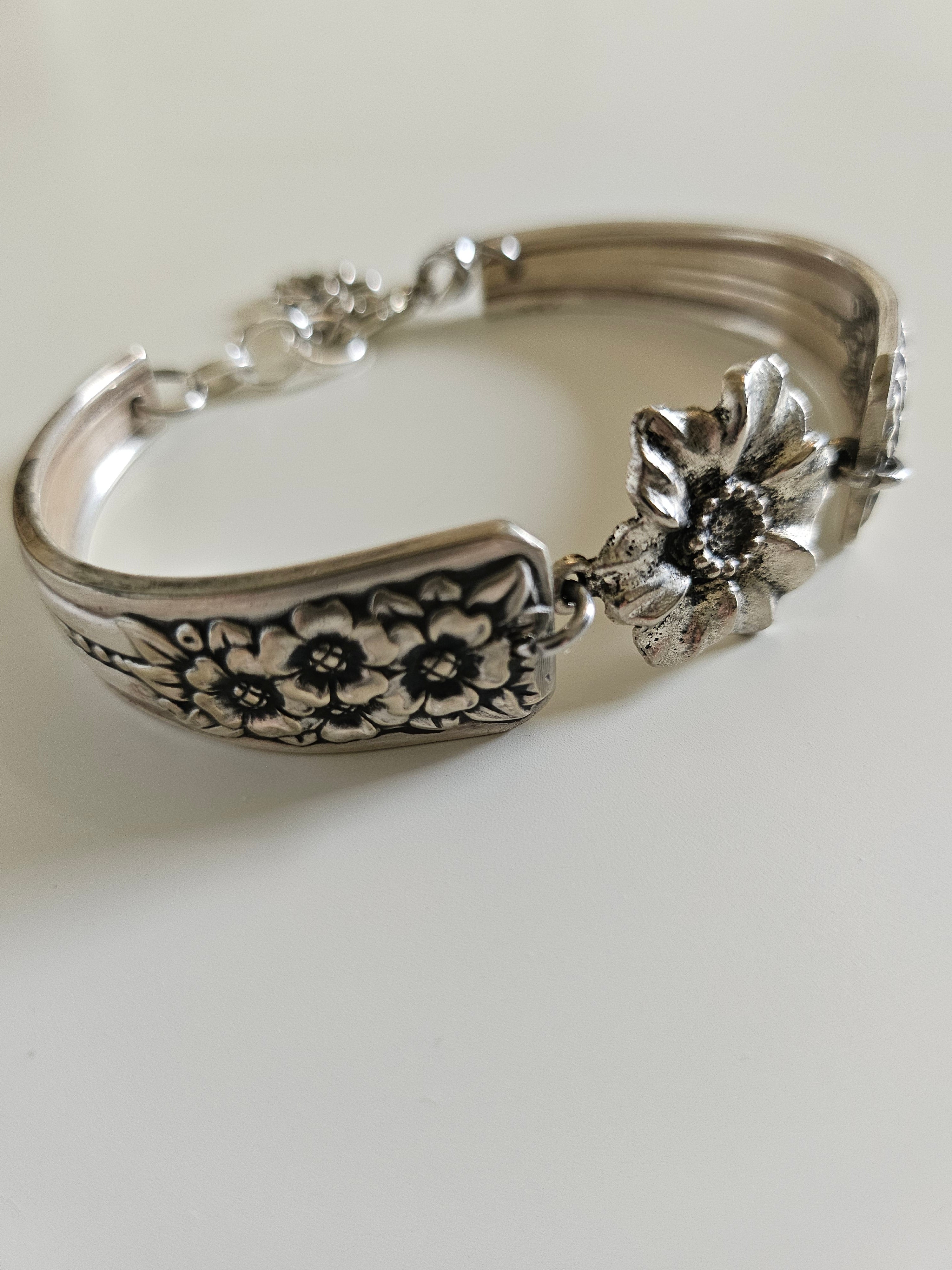 Handcrafted bracelet made from 1953 Jubilee silverware with vintage floral beads. A unique, repurposed piece blending antique charm and modern elegance.