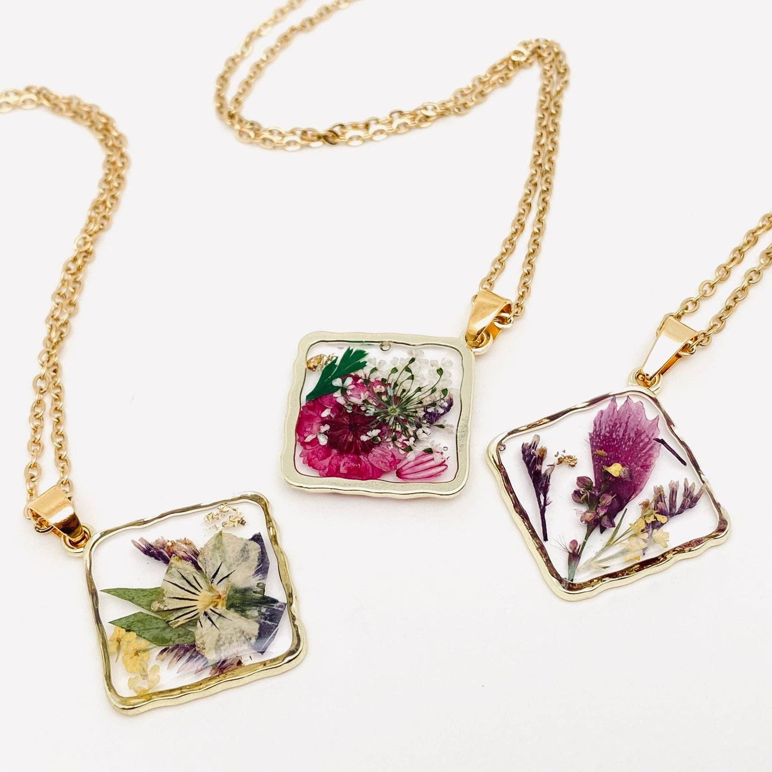 Handcrafted square pendant necklace with real pressed dried flowers in clear resin. Unique botanical jewelry with stainless steel chain and copper frame.