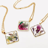 Handcrafted square pendant necklace with real pressed dried flowers in clear resin. Unique botanical jewelry with stainless steel chain and copper frame.