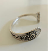 Handcrafted from 1953 Jubilee silverware, this vintage cuff bracelet features delicate floral details and pink crystals for a timeless, romantic sparkle