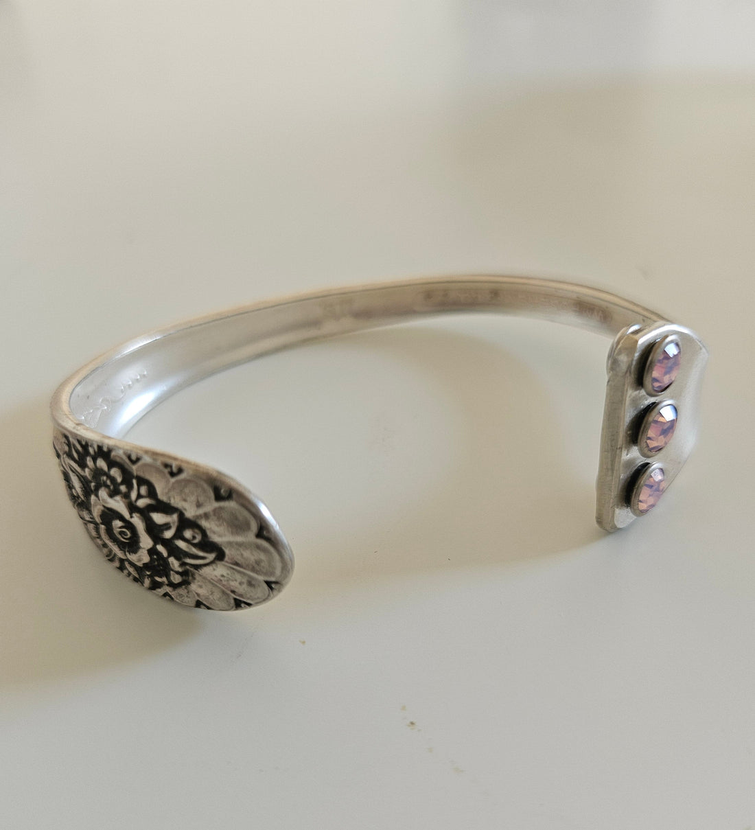 Handcrafted from 1953 Jubilee silverware, this vintage cuff bracelet features delicate floral details and pink crystals for a timeless, romantic sparkle