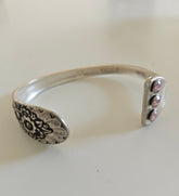 Handcrafted from 1953 Jubilee silverware, this vintage cuff bracelet features delicate floral details and pink crystals for a timeless, romantic sparkle