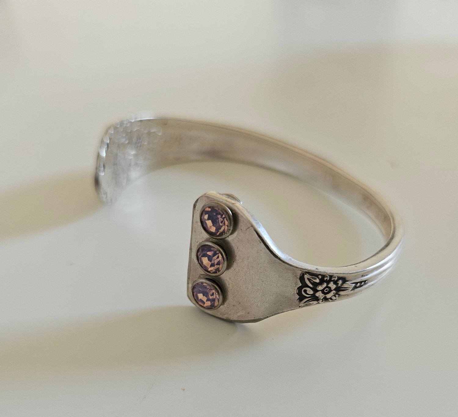 Handcrafted from 1953 Jubilee silverware, this vintage cuff bracelet features delicate floral details and pink crystals for a timeless, romantic sparkle
