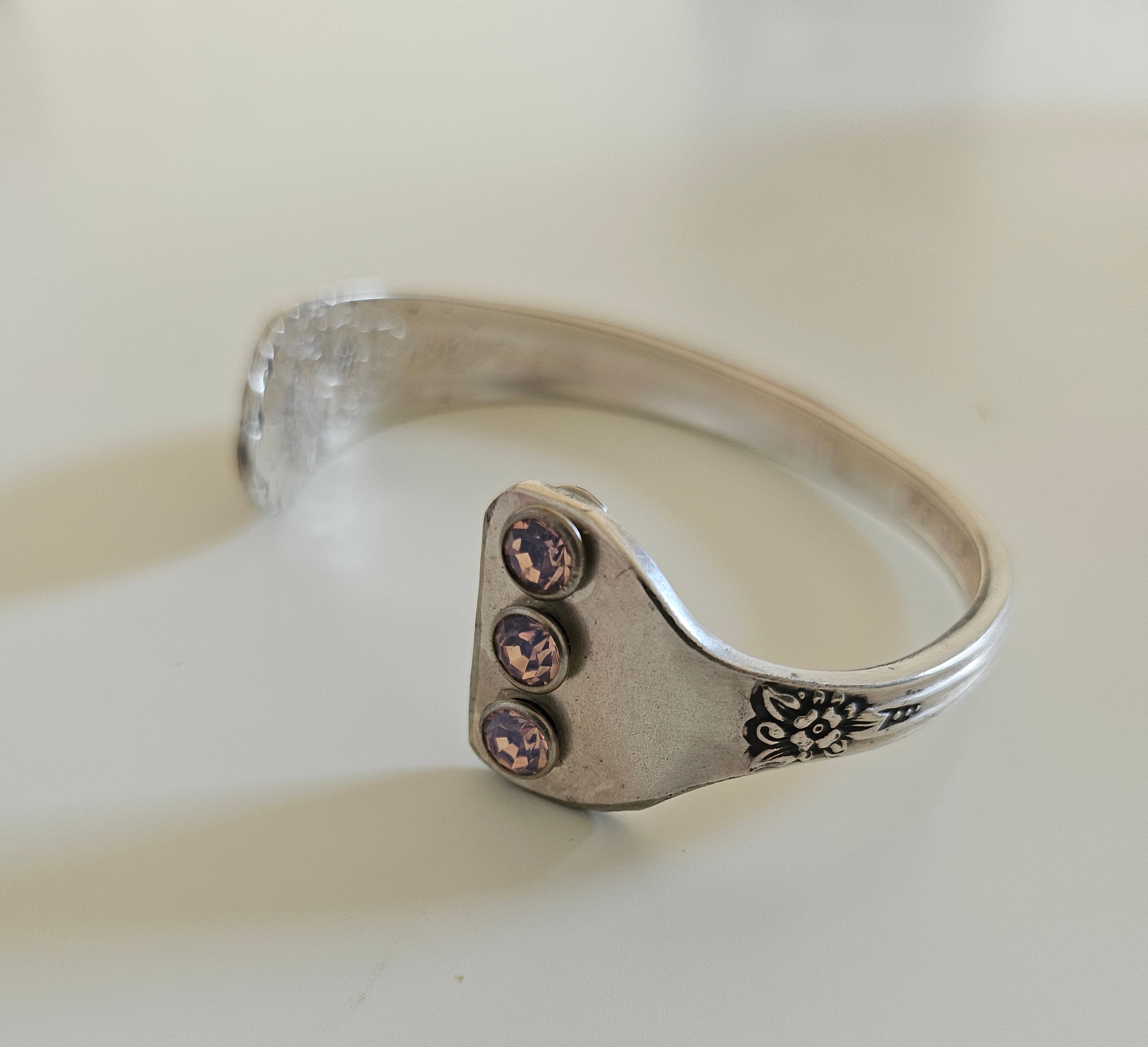 Handcrafted from 1953 Jubilee silverware, this vintage cuff bracelet features delicate floral details and pink crystals for a timeless, romantic sparkle
