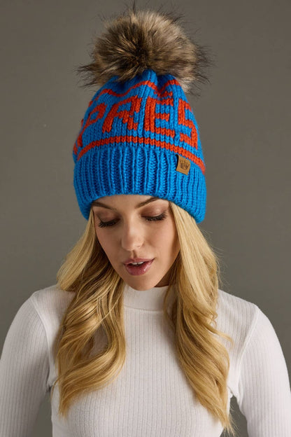 Blue and orange Après knit hat with a natural-toned faux fur pom and cozy fleece lining. Made from 100% acrylic for colorful, comfortable winter style.