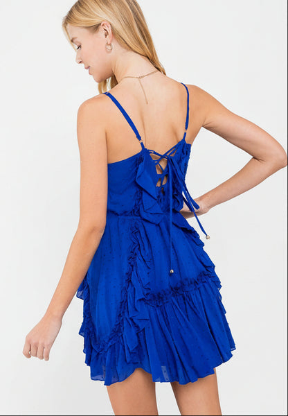 Swiss dot mini dress with ruffle details, lace-up back, adjustable straps &amp; waist tie. Lightweight rayon, perfect for warm days &amp; effortlessly chic looks.