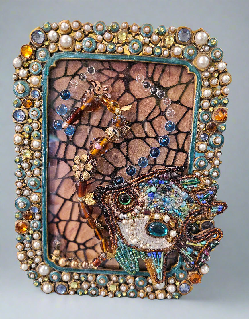 Add a splash of nautical charm with Jeweled Fish Frames, featuring handcrafted aquatic motifs in high-quality beads, glass, wood, and metal. These 4&quot; x 6&quot; frames blend intricate craftsmanship with vintage-inspired elegance, making them perfect for walls, shelves, or gallery displays. A unique decor statement!