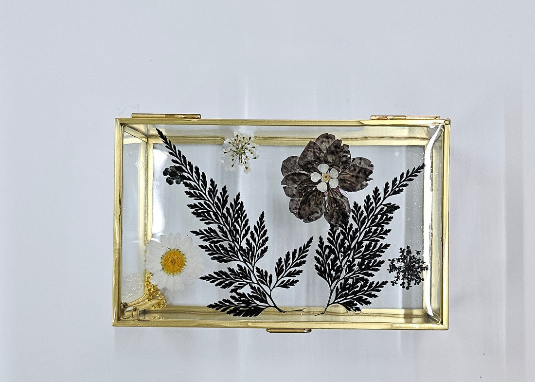 Elegant 6”x4” glass and metal display box with pressed flowers for jewelry, botanicals, and keepsakes. Perfect for showcasing small treasures in a modern, timeless style.