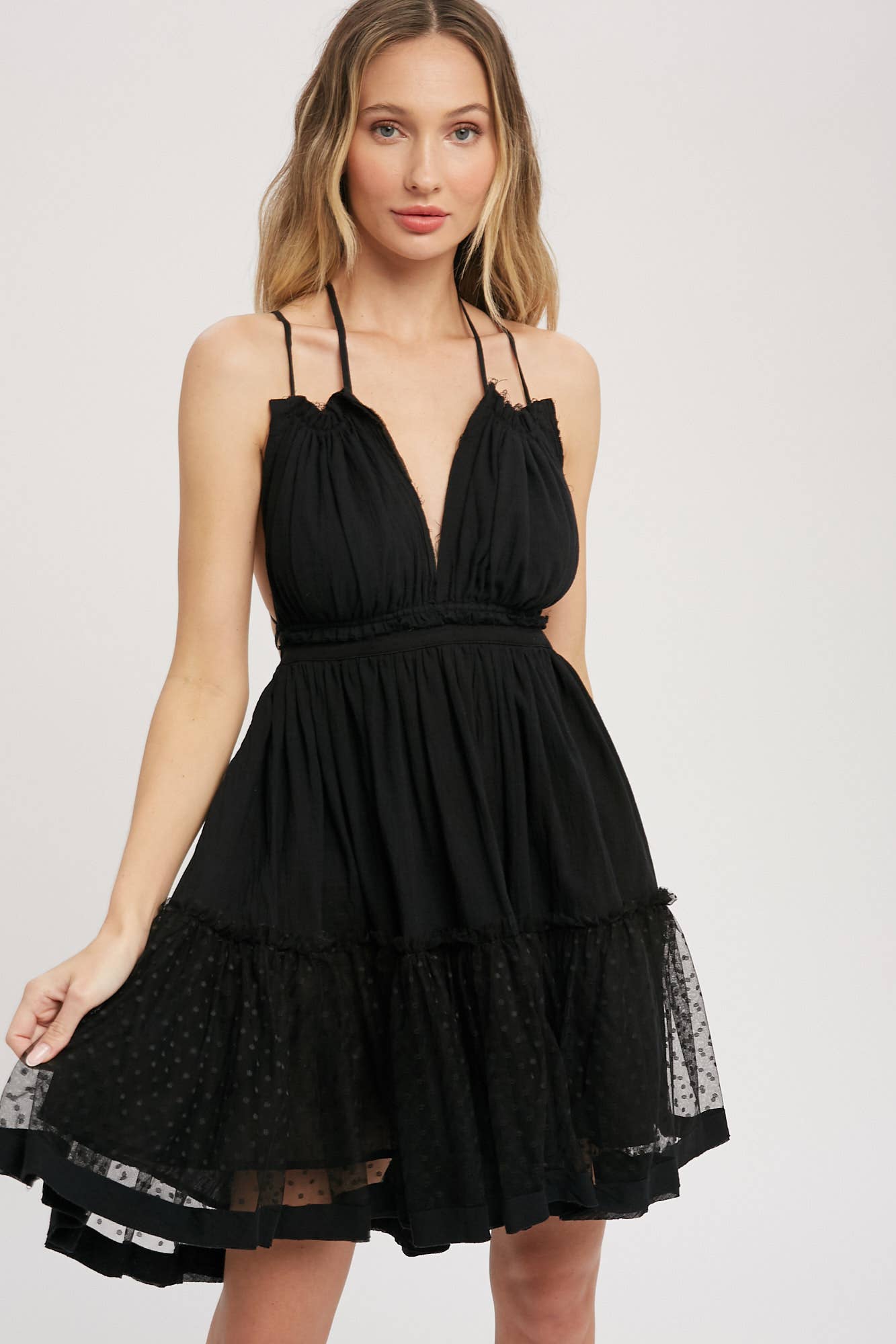 Black gauze swing mini dress with halter tie bust, backless design, elastic waist, and mesh ruffle hem. Lightweight summer party dress.