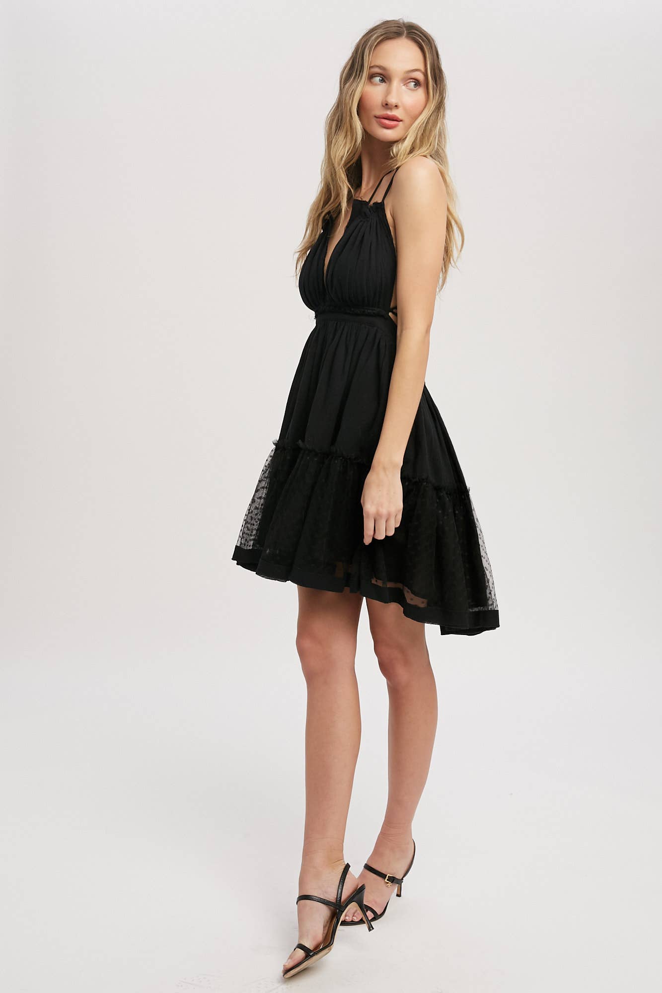 Black gauze swing mini dress with halter tie bust, backless design, elastic waist, and mesh ruffle hem. Lightweight summer party dress.