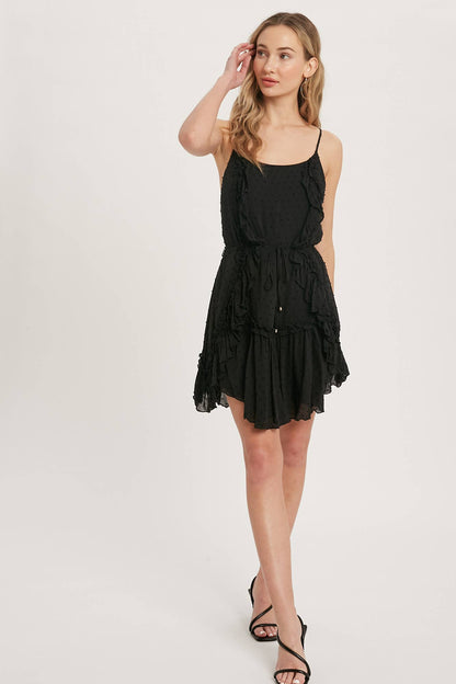 Swiss dot mini dress with ruffle details, lace-up back, adjustable straps &amp; waist tie. Lightweight rayon, perfect for warm days &amp; effortlessly chic looks.