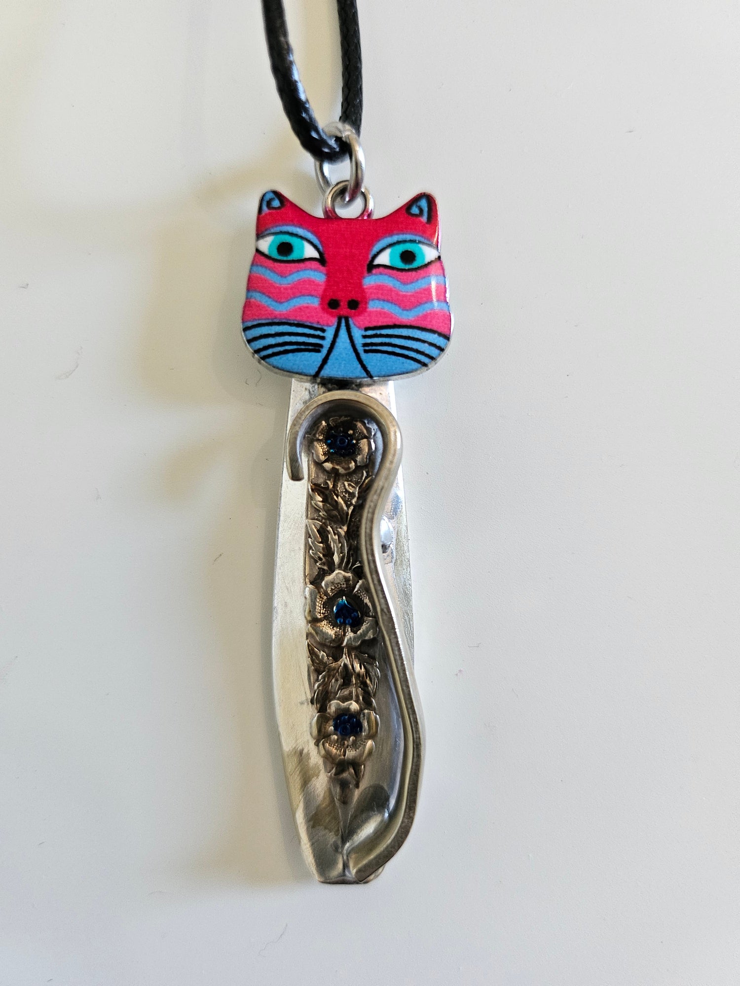 Handcrafted vintage silverware necklaces featuring enamel cat faces on adjustable satin cords. Made from 1951 Distinction and 1952 Primrose patterns.