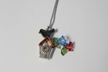 Handcrafted small birdhouse necklace made from reclaimed vintage silverware. Whimsical, cottagecore, eco-friendly jewelry perfect for nature lovers and unique gift giving.