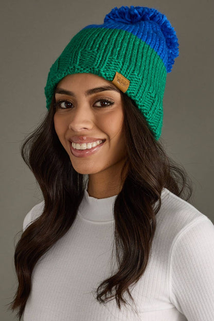 Blue and green color block pom hat by Panache Apparel Co. Made from 100% acrylic with cozy fleece lining and a large pom for cheerful winter style.