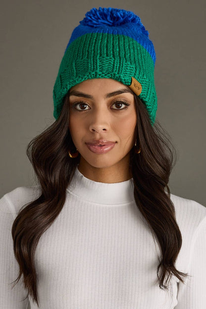 Blue and green color block pom hat by Panache Apparel Co. Made from 100% acrylic with cozy fleece lining and a large pom for cheerful winter style.