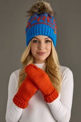 Blue and orange Après knit hat with a natural-toned faux fur pom and cozy fleece lining. Made from 100% acrylic for colorful, comfortable winter style.