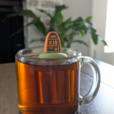 Plant Bookshelf Tea Steeper makes loose leaf tea easy in any cup. Reusable, dishwasher safe, eco-friendly. A perfect gift for tea and book lovers.
