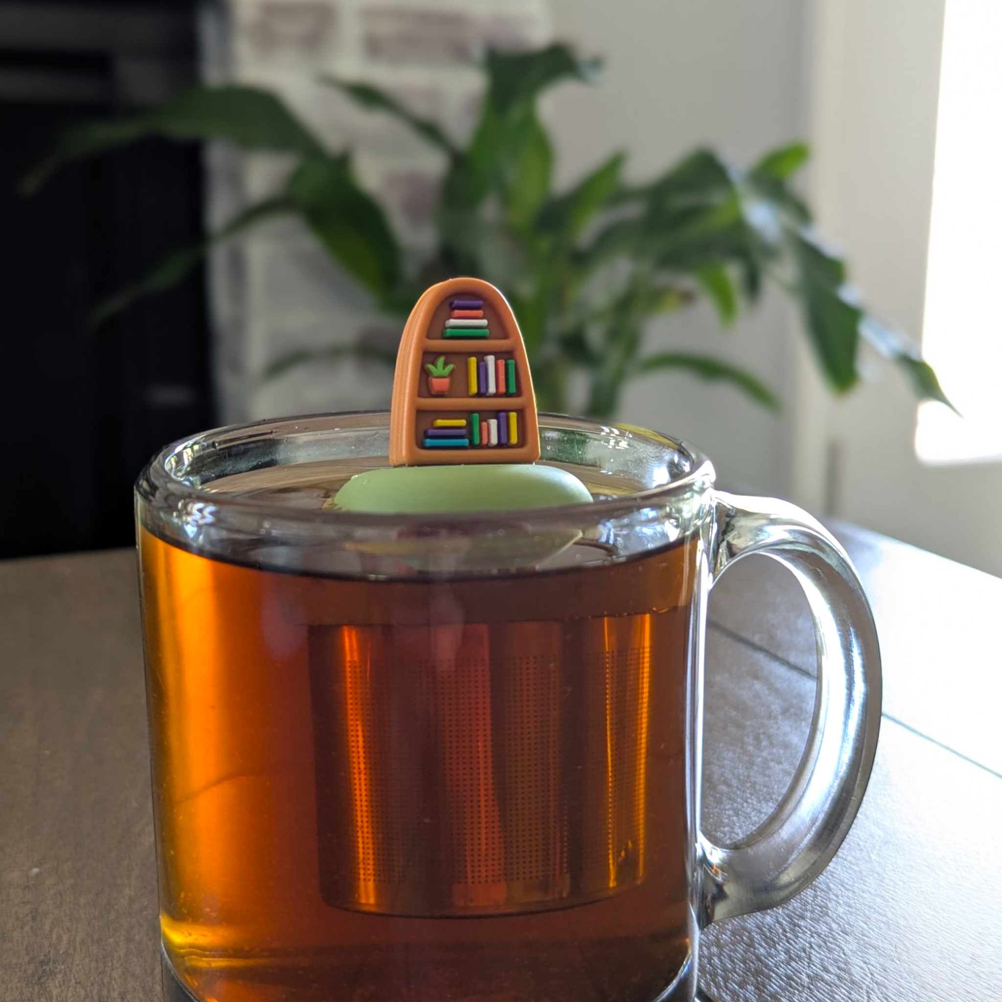 Plant Bookshelf Tea Steeper makes loose leaf tea easy in any cup. Reusable, dishwasher safe, eco-friendly. A perfect gift for tea and book lovers.