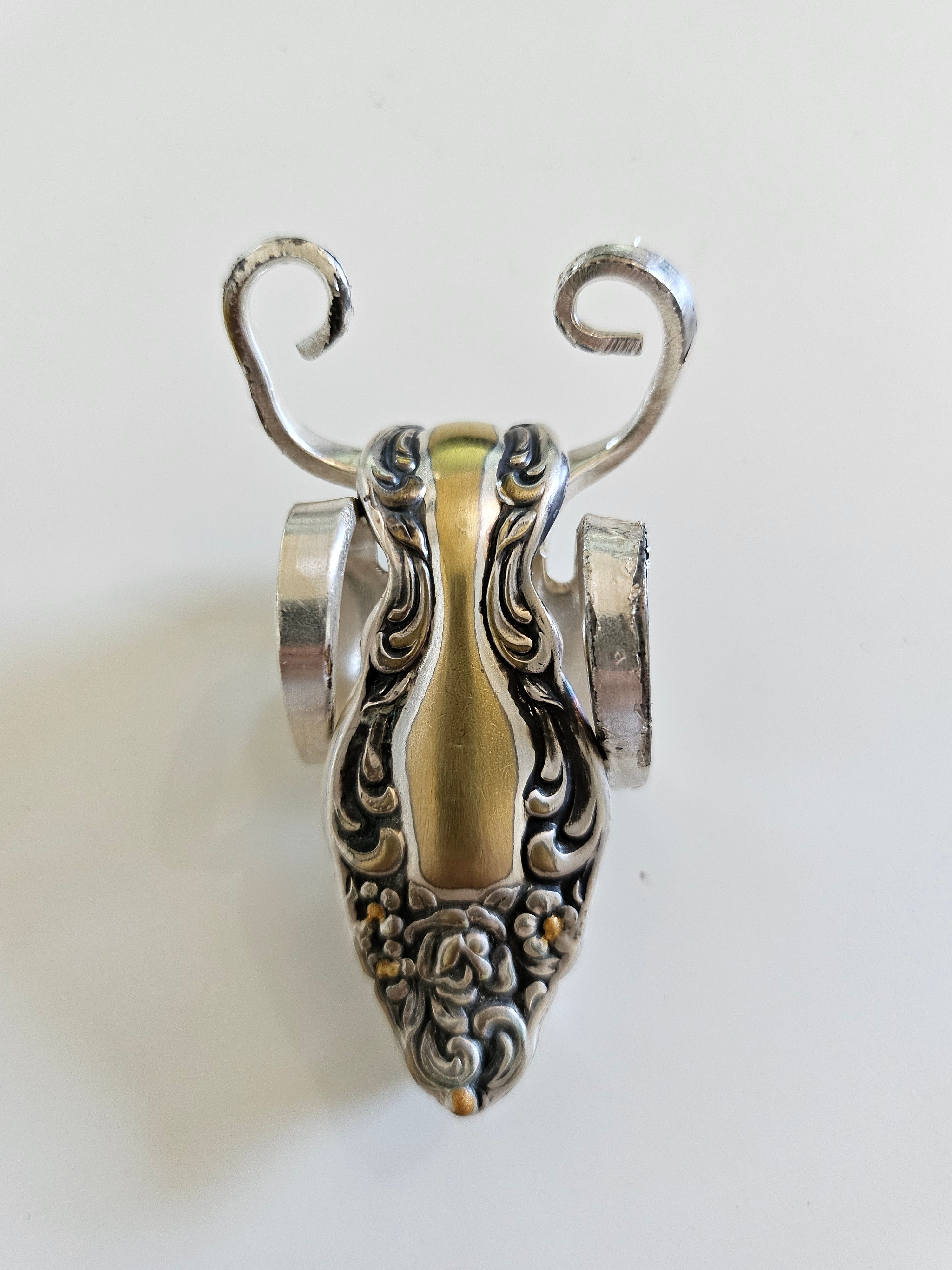The Lucky Fork Cricket is a handcrafted sculpture made from repurposed vintage silverware, blending artistry with charm. Inspired by crickets—symbols of luck and prosperity—each piece is unique, adorned with jewels and aged patina. A perfect collectible or gift, this whimsical creation brings history, elegance, and positive energy to any space. 