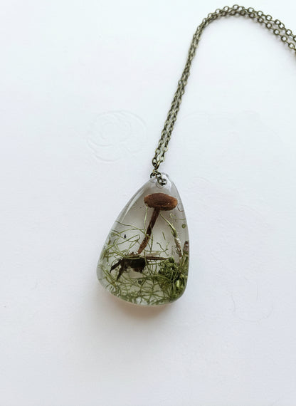 Gathered-in-the-Wild Botanical Necklace with real foraged flowers, mushrooms, pine needles, and leaves preserved in resin. Handcrafted wearable nature art by KStonely.