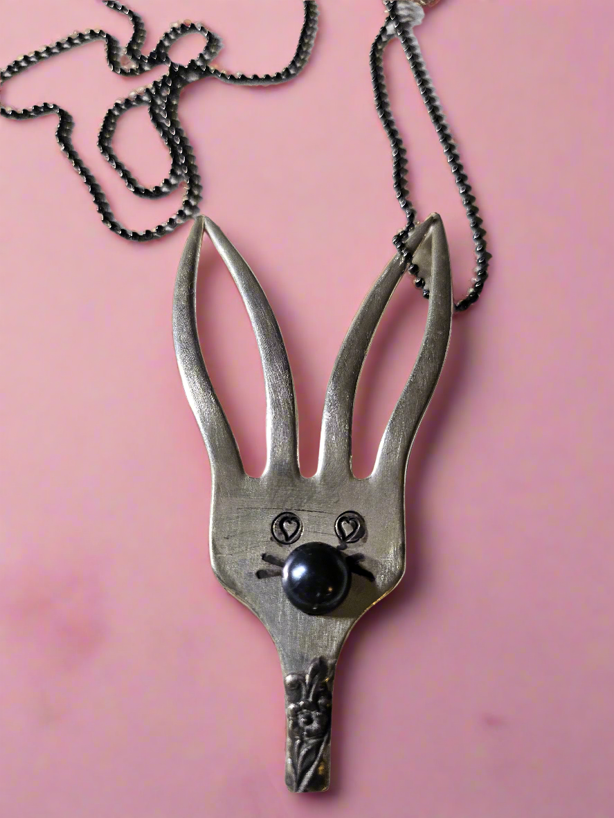 The Salvaged Silver Bunny Pendant is a handcrafted, one-of-a-kind piece made from recycled vintage silverware. Designed by artisan KStonely, it blends whimsical Easter charm with sustainable craftsmanship. Lightweight and unique, it’s perfect for everyday wear or special occasions. A timeless, upcycled treasure that celebrates history and artistry. 