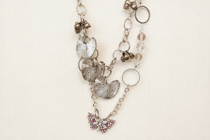 Pink Butterfly Curated Chaos Layered Charm Necklace handcrafted by artist KStonely with chains, ribbon, beads, and unique charms. One-of-a-kind mixed-media wearable art jewelry.
