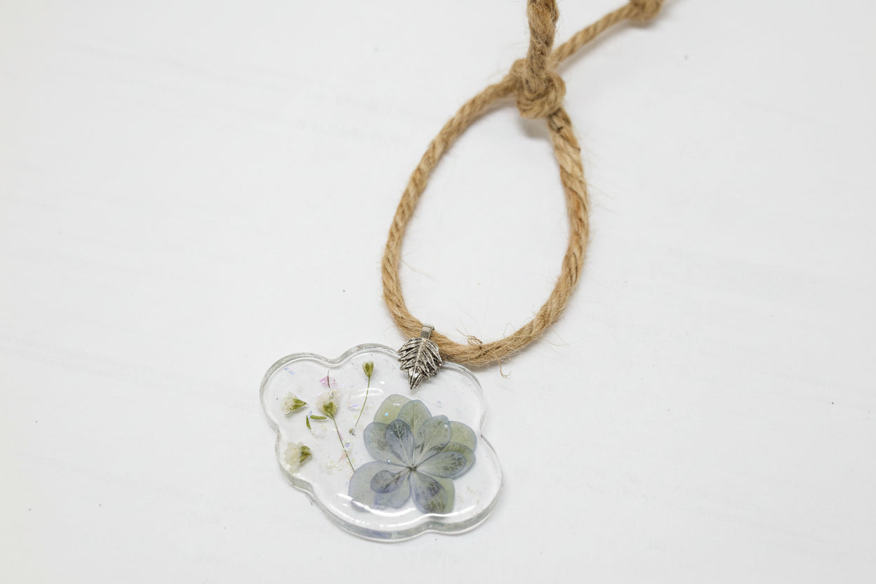 Pressed flower resin suncatcher ornaments with real botanicals in heart, butterfly, and organic shapes—handmade, one-of-a-kind nature keepsakes by Angel Singh.