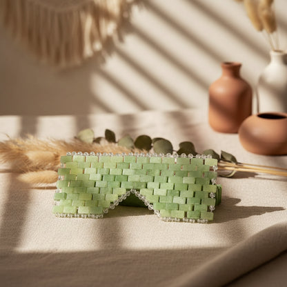 Cooling or warming jade eye mask made from 100% real jade beads. Reduces puffiness, soothes tension, boosts circulation, and brings calm, balance, and radiant renewal.