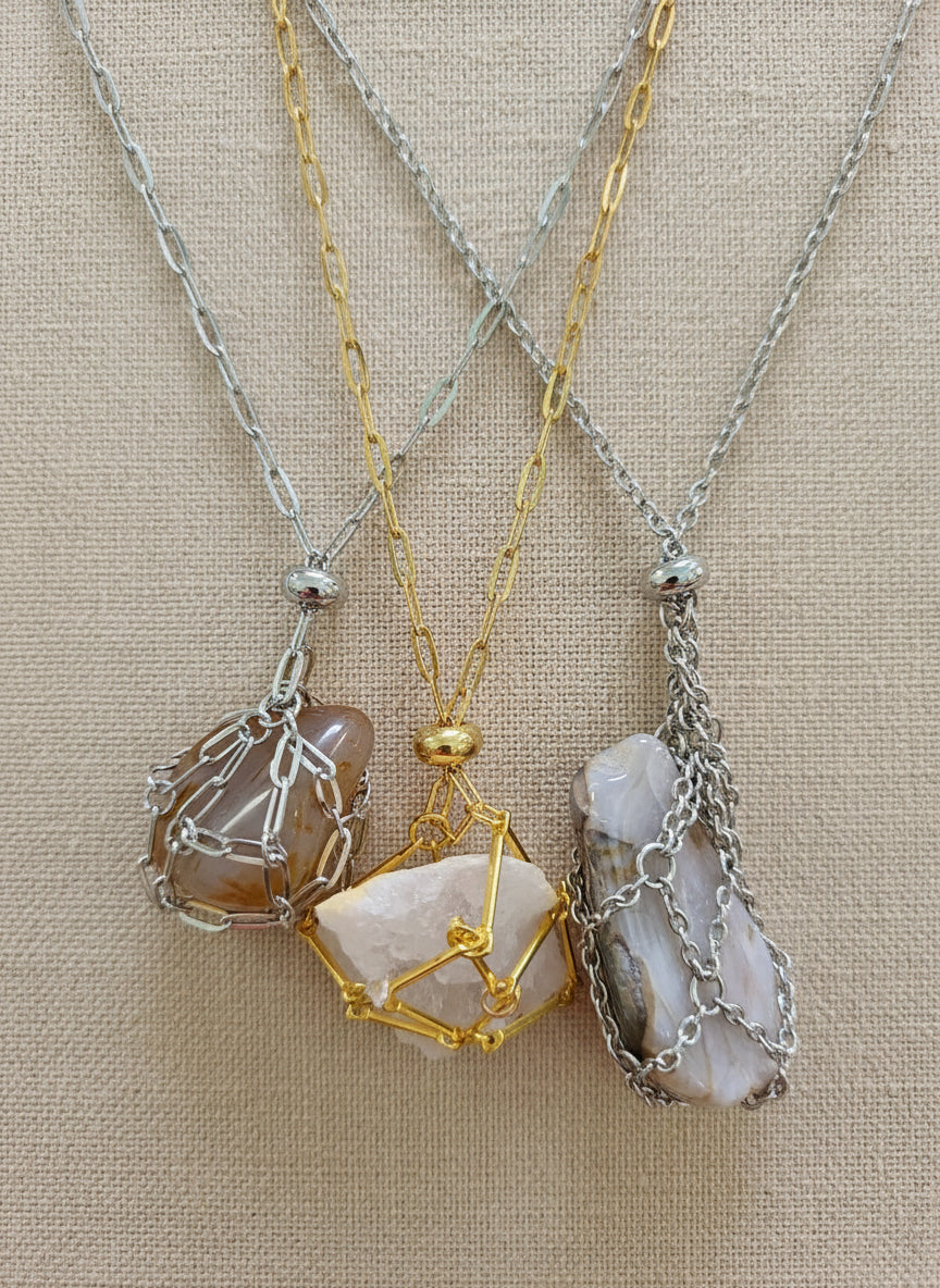 A versatile Crystal and Rock Cage Necklace with an adjustable metal pendant. Swap in your favorite gemstones or charms for a personalized, mystical accessory.