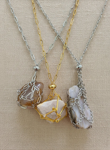 A versatile Crystal and Rock Cage Necklace with an adjustable metal pendant. Swap in your favorite gemstones or charms for a personalized, mystical accessory.