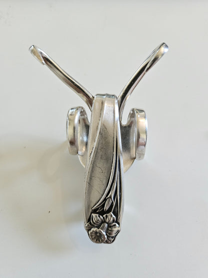 The Lucky Fork Cricket is a handcrafted sculpture made from repurposed vintage silverware, blending artistry with charm. Inspired by crickets—symbols of luck and prosperity—each piece is unique, adorned with jewels and aged patina. A perfect collectible or gift, this whimsical creation brings history, elegance, and positive energy to any space. 