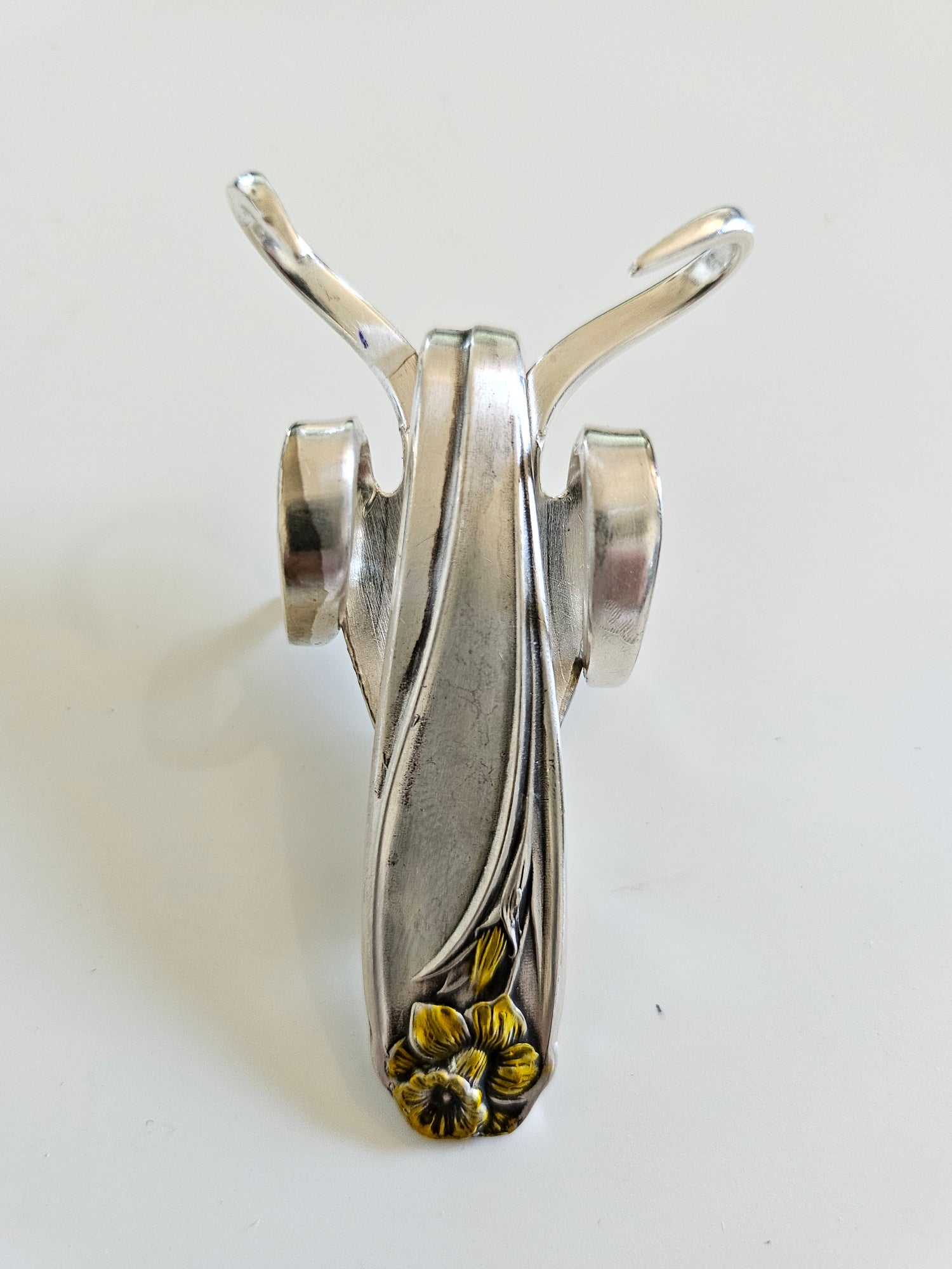 The Lucky Fork Cricket is a handcrafted sculpture made from repurposed vintage silverware, blending artistry with charm. Inspired by crickets—symbols of luck and prosperity—each piece is unique, adorned with jewels and aged patina. A perfect collectible or gift, this whimsical creation brings history, elegance, and positive energy to any space. 