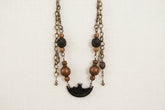 Layered antique-style chains with earthy beads and a charm tassel. The Nomad Layer Necklace is a soulful, wander-inspired statement.