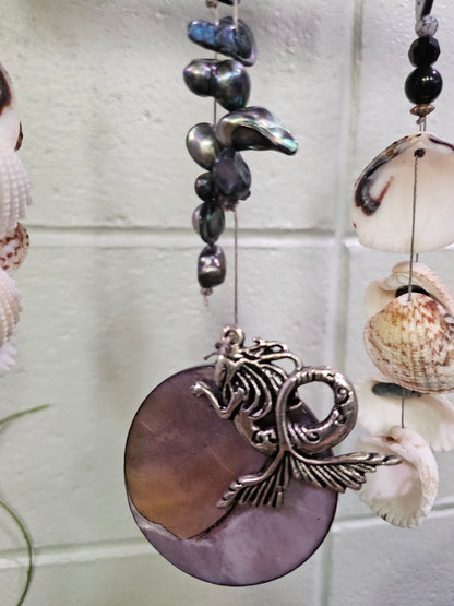 Add coastal charm to your space with the Shell &amp; Bead Bohemian Suncatcher. Handcrafted with natural shells, semi-precious stones, and beads, it captures sunlight to create a stunning display of light and texture, perfect for windows, gardens, or as a unique, nature-inspired gift.